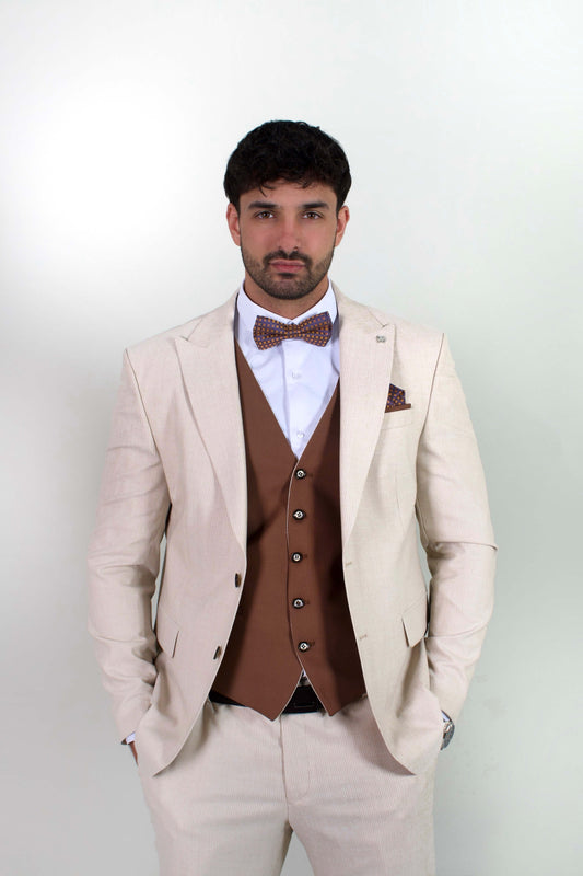 Елегантен мъжки костюм от три части в светлобежов цвят с вталена slim fit кройка, кафява жилетка и папийонка, подходящ за сватба или бал.